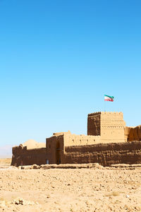 Built structure on beach against clear blue sky