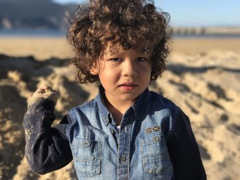 Portrait of young kid standing at beach