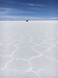 Scenic view of salt flat against blue sky during sunny day