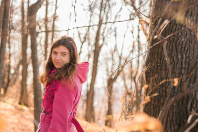 Portrait of young woman standing in forest