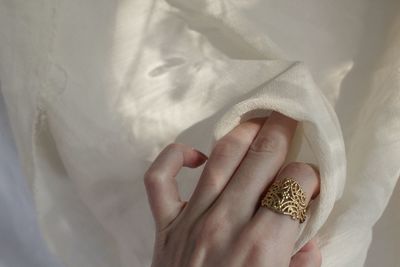 Close-up of woman hand on white bed