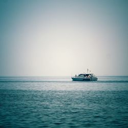 Boat sailing in sea against clear sky