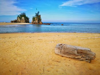 Scenic view of rocks on beach against sky