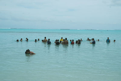 Group of people swimming in sea