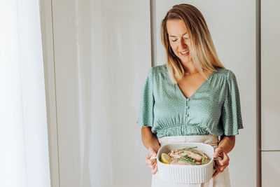 Young european woman holding a tray with food and smiling