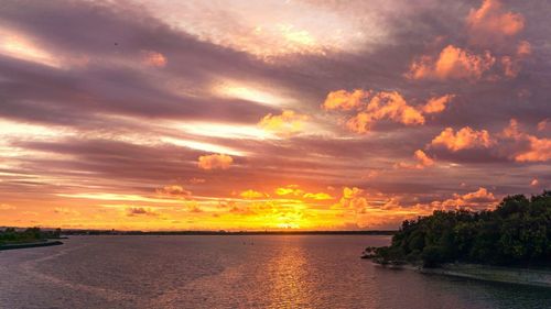 Scenic view of sea against dramatic sky during sunset