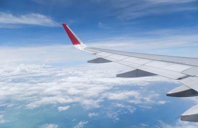 Airplane flying over clouds against sky