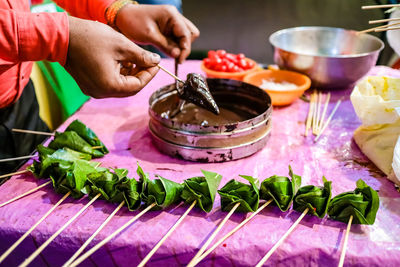 Close-up of person preparing food on table