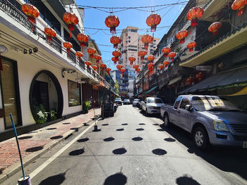 Lantern lined street amidst buildings in city