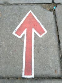 Close-up of arrow sign on road