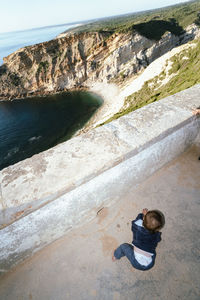 Rear view of man sitting on road