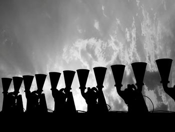 Low angle view of speakers against sky