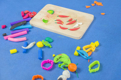High angle view of multi colored clay toys on blue background
