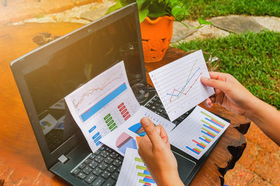 Cropped image of woman with graphs at table