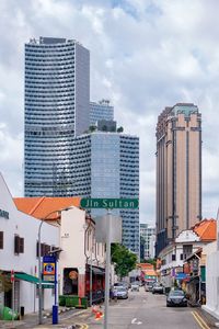 View of city street and buildings against sky