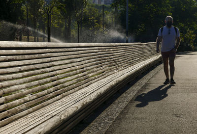 Rear view of man walking on walkway