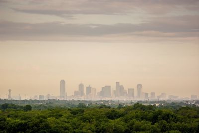 View of cityscape against cloudy sky