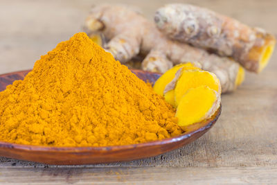 Close-up of ground turmeric on wooden table