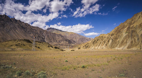 Scenic view of field and mountains against sky