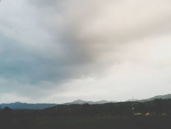 Scenic view of mountains against cloudy sky