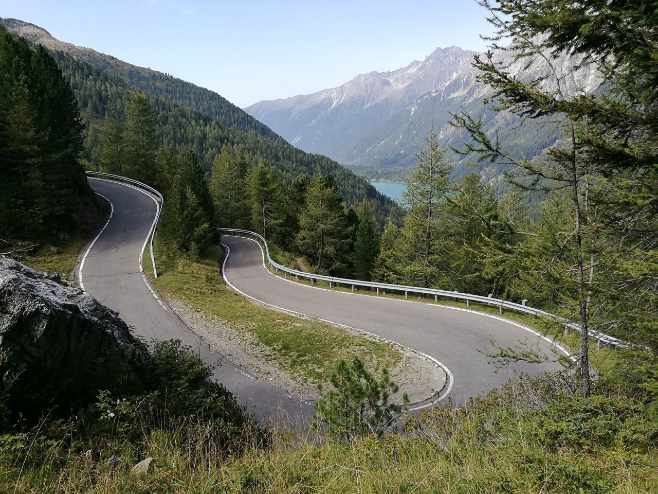 mountain, transportation, curve, road, winding road, beauty in nature, nature, high angle view, car, speed, mountain range, mountain road, day, scenics, no people, motion, sky, landscape, tree, outdoors