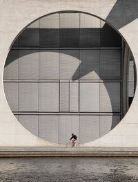 Reflection of man on building in city