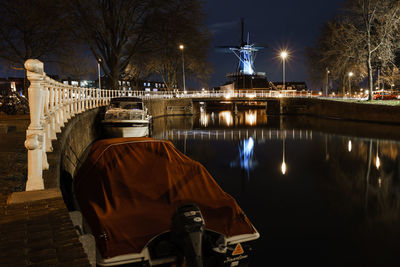 Boats on canal in city at night