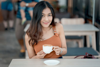 Portrait of smiling woman sitting at restaurant table