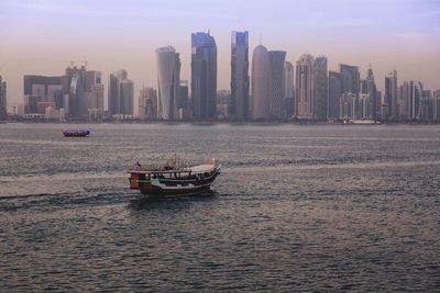 Boat in city at sunset