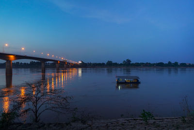 Bridge over lake against sky at night