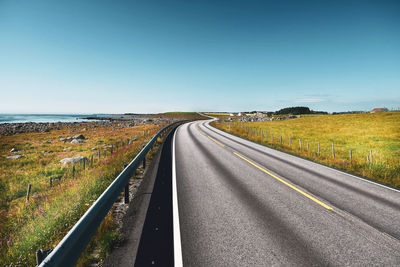 Empty road along countryside landscape