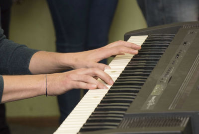 Midsection of man playing piano