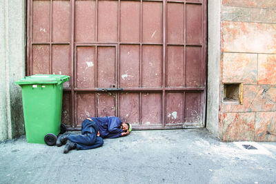 Garbage can on street against building