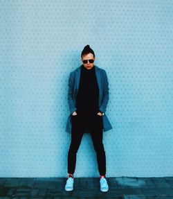 Portrait of man standing against wall