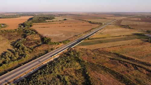 High angle view of road amidst field against sky