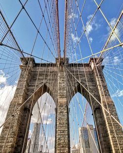 Low angle view of suspension bridge against sky