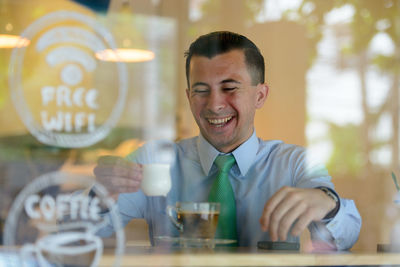 Portrait of smiling young man holding drink