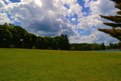 Scenic view of grassy field against cloudy sky