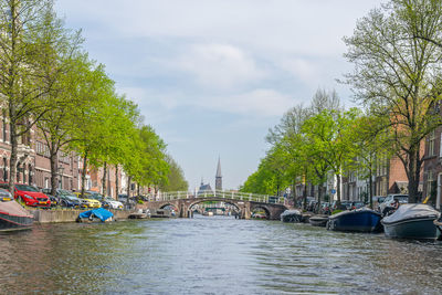 Bridge over canal in city against sky