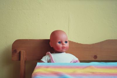 Doll on wooden bench at home