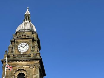 Low angle view of clock tower against blue sky