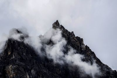 Low angle view of rocky mountain against sky