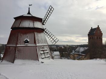 Building on snow covered field against sky