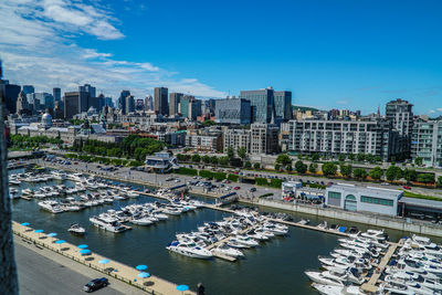 High angle view of harbor by buildings against blue sky