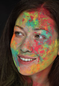 Close-up portrait of a smiling young woman with holi