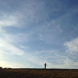Silhouette woman standing on landscape against sky