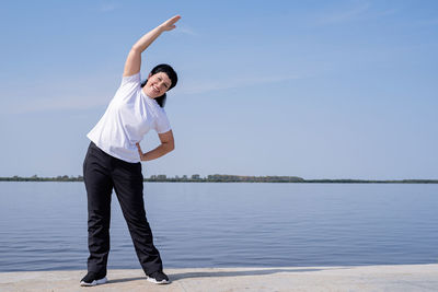 Full length of man standing on lake against sky