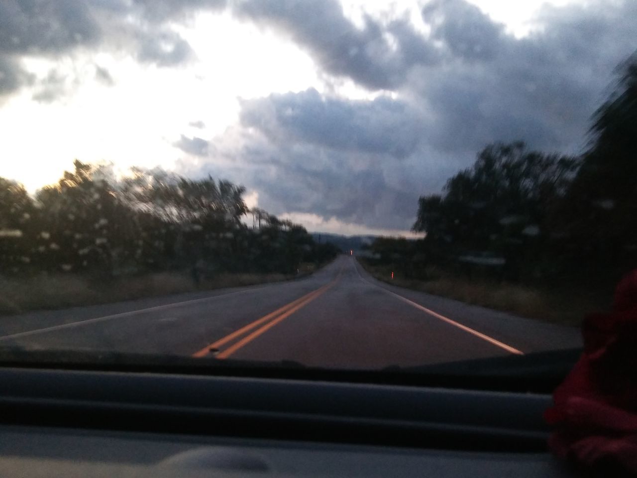 ROAD SEEN THROUGH WINDSHIELD OF CAR