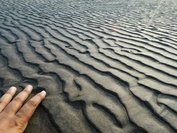 Close-up of hand on sand at beach