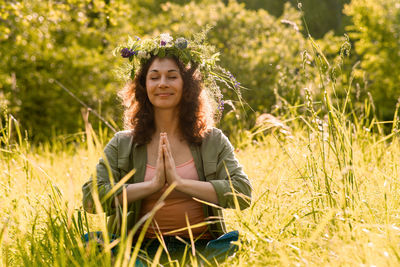 Portrait of young woman sitting on field
